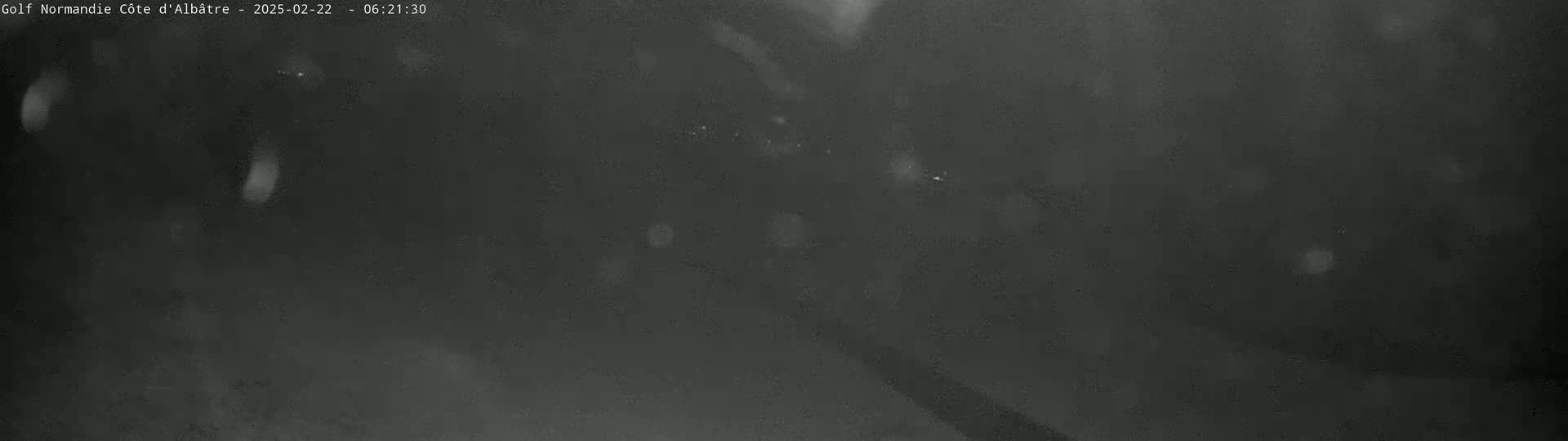 A dark, blurry image shows what appears to be light snow falling at night.