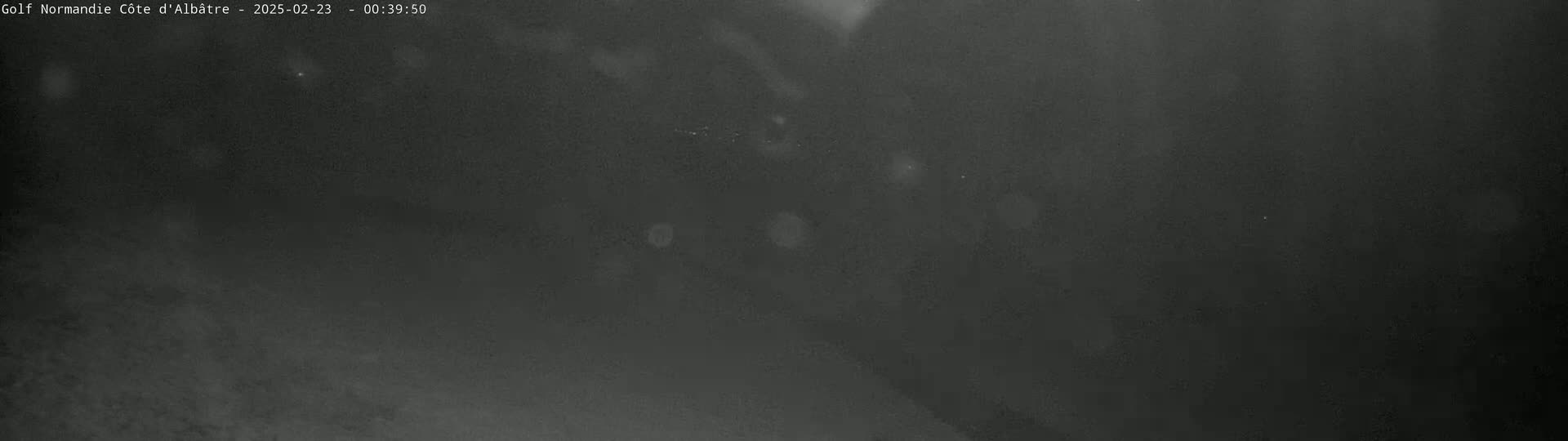 A dark, blurry image shows a nighttime scene with several indistinct light sources visible in the distance.