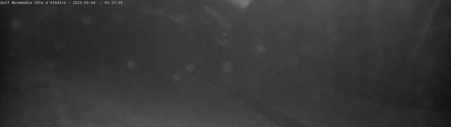 A dark, blurry image shows a night scene with scattered light spots.