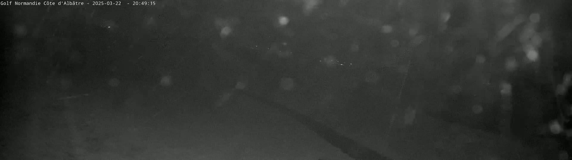 A dark, blurry image shows what appears to be snow falling at night.