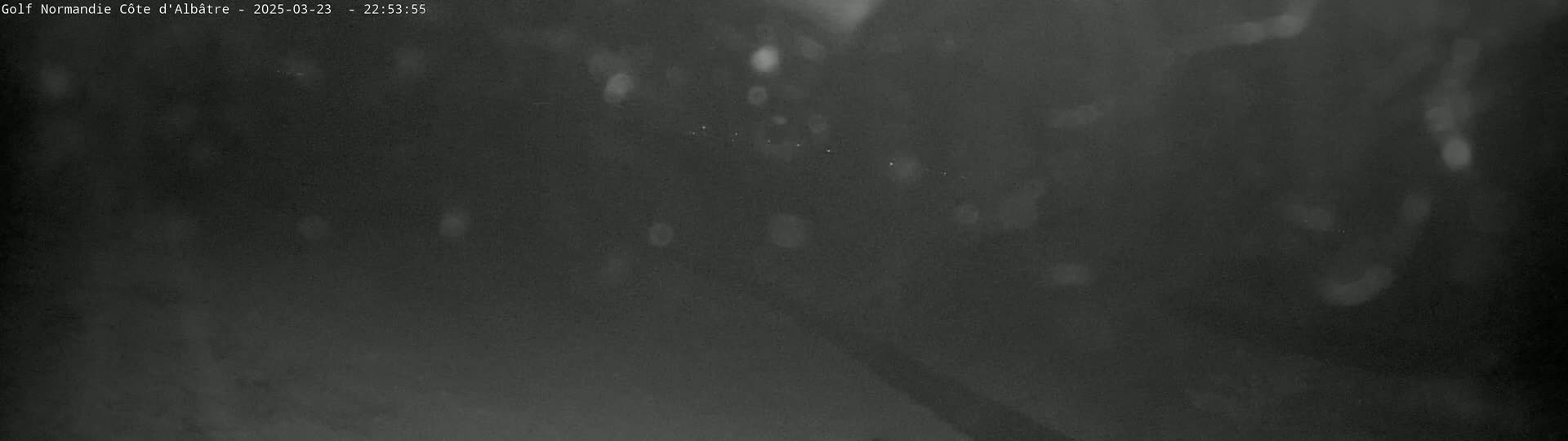 A dark, blurry nighttime image shows indistinct shapes and faint lights.