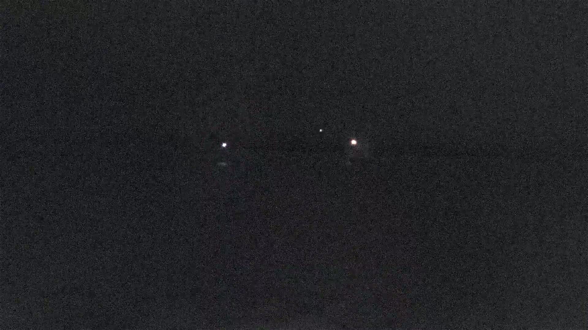 Three small, faint lights are visible in the dark night sky.