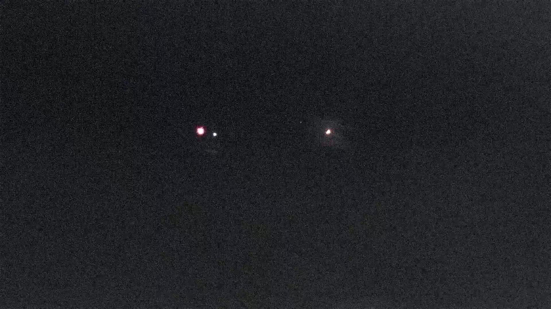 Two small, faint lights are visible in the inky blackness of the night sky.