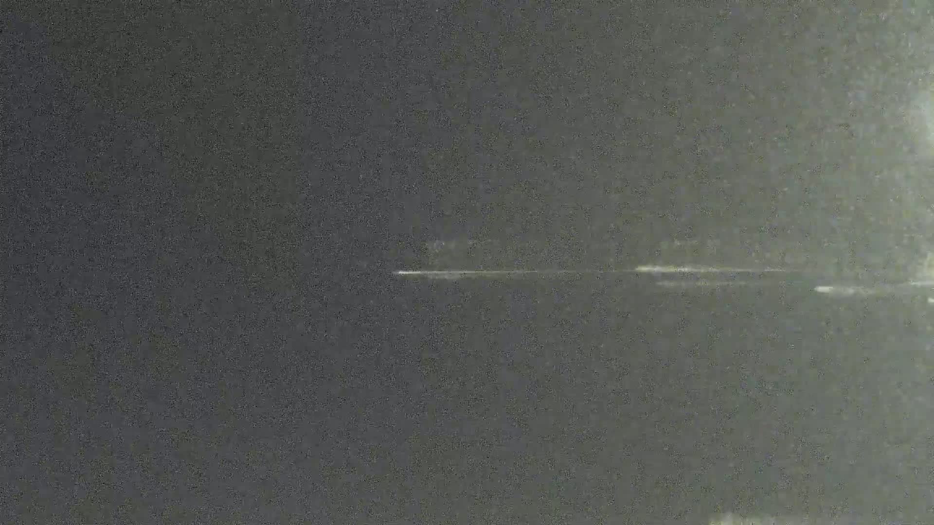 A dark, grainy image shows a thin, horizontal line of light against a mostly black background.