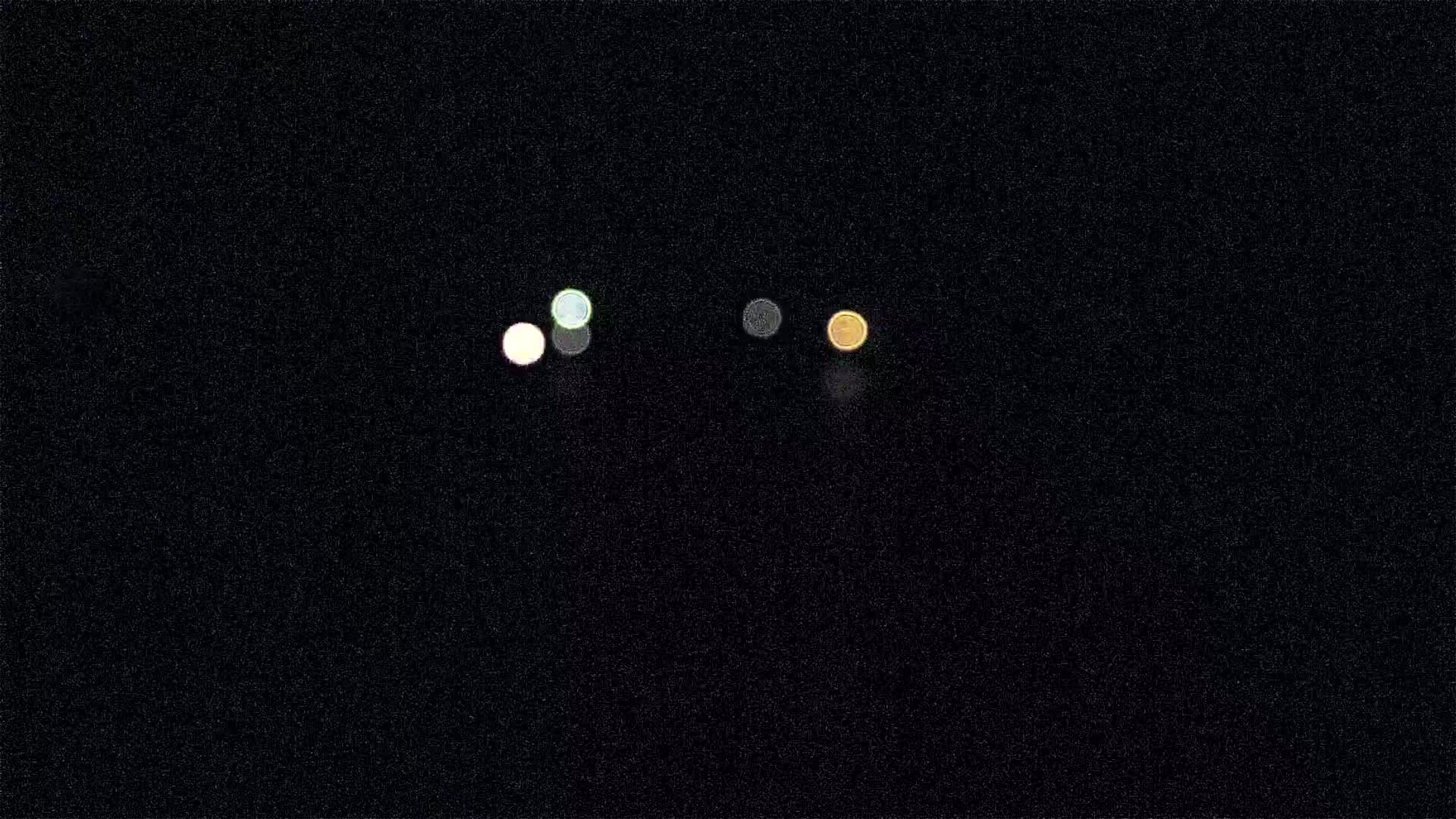 Four blurry, out-of-focus lights of varying colors are visible against a dark, nighttime sky.