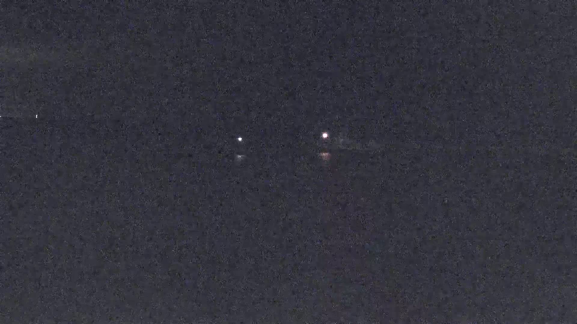 Three faint lights are visible in the dark night sky.