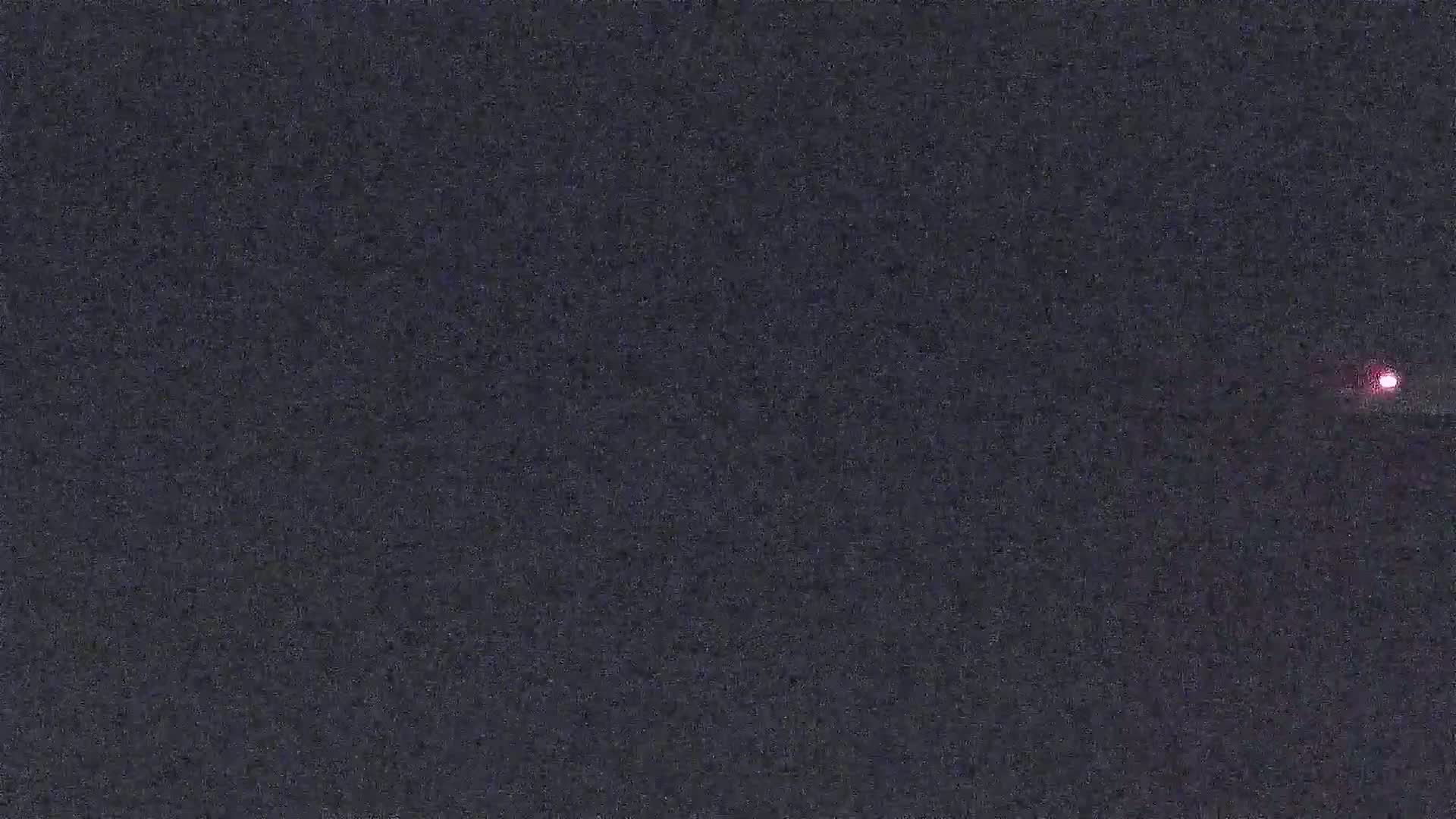 A small, reddish light is visible in the night sky.