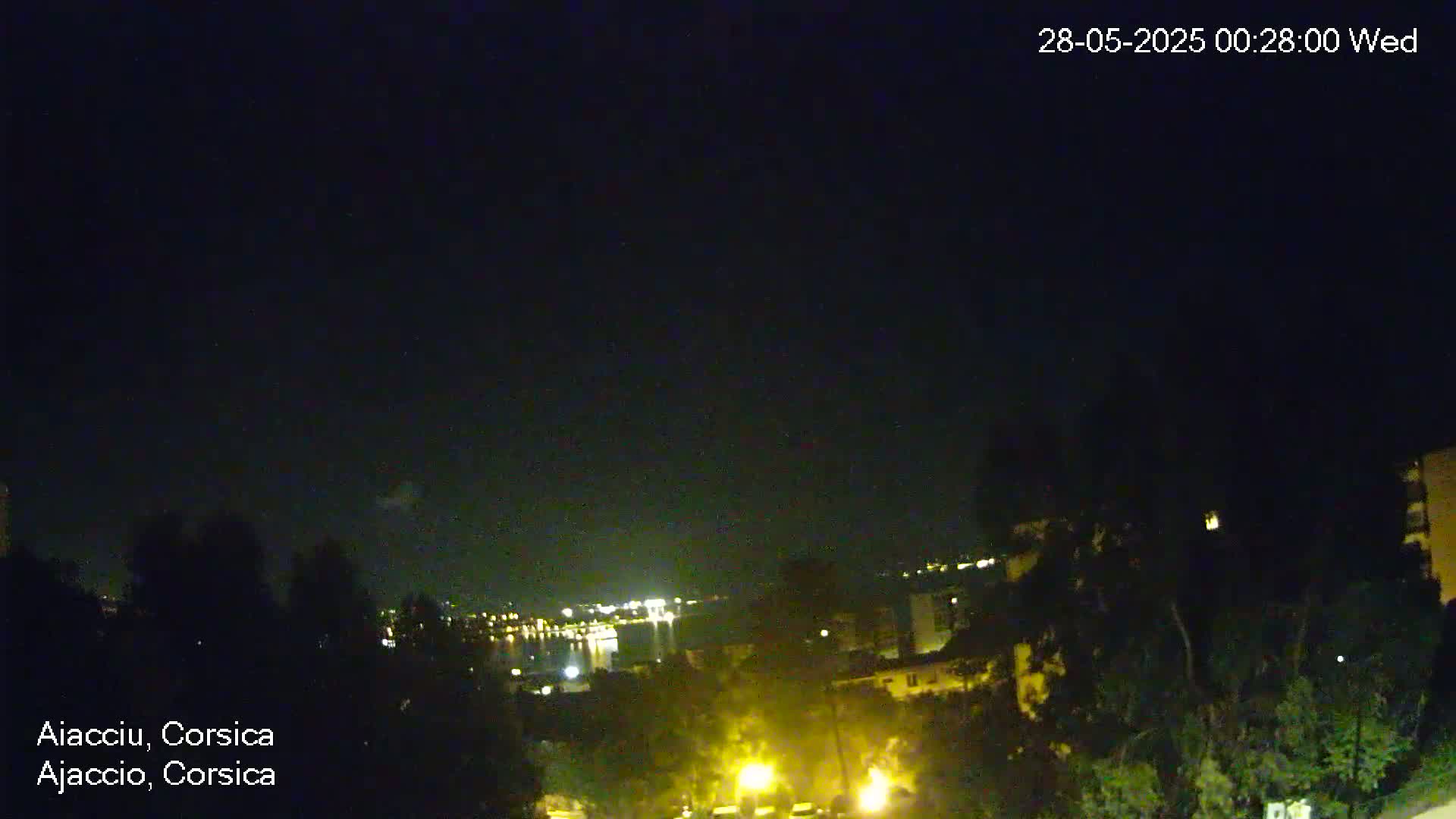 A nighttime view of a city by the water, under a clear, dark sky.