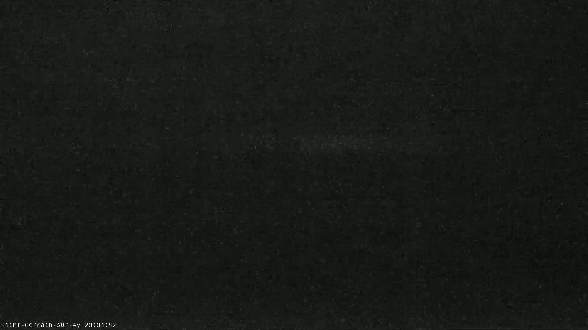 The image shows a dark, grainy surface, possibly asphalt or a similar material, under nighttime conditions.