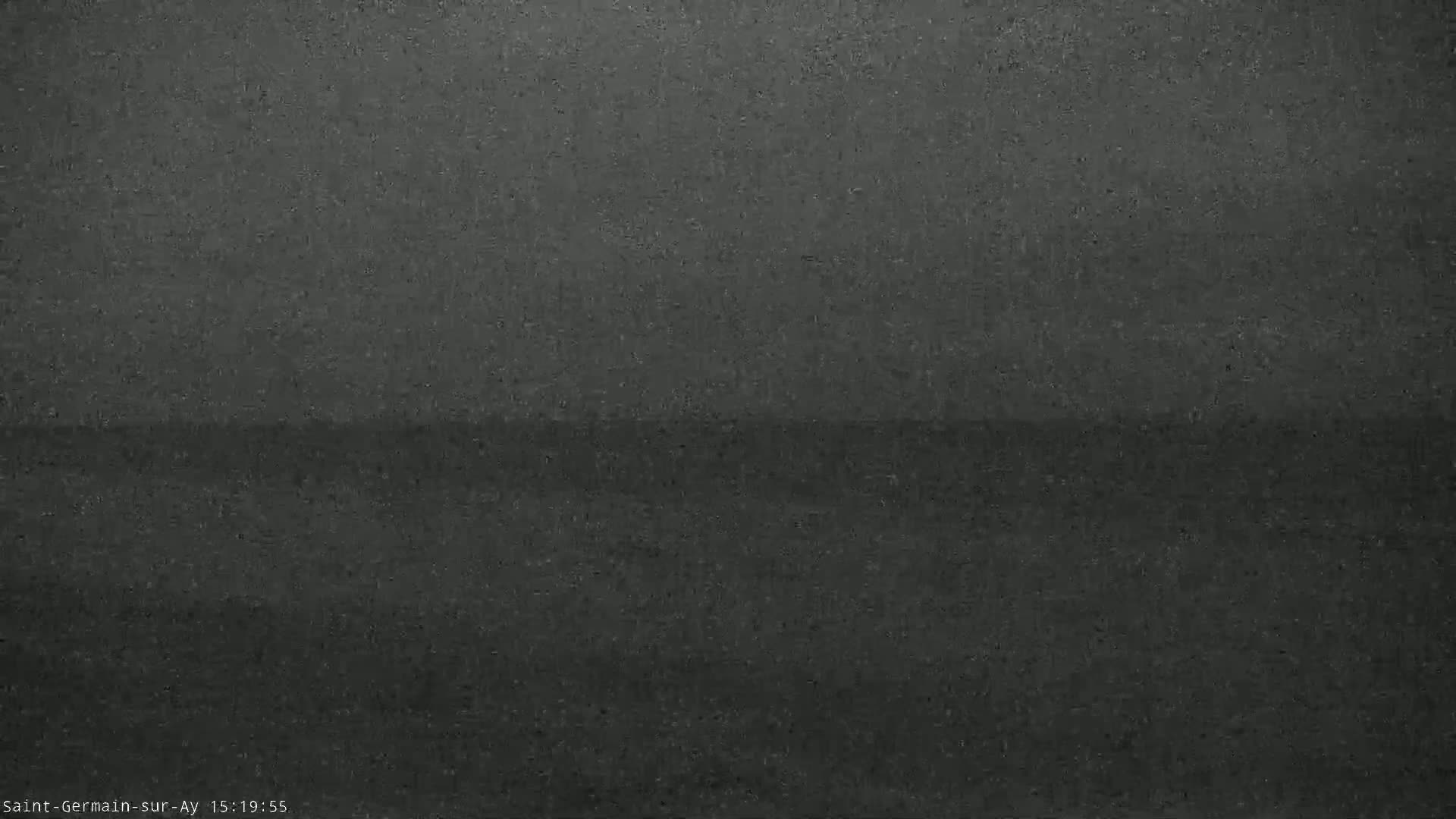 A dark gray, possibly overcast, outdoor scene shows a blurry, indistinct horizon line.