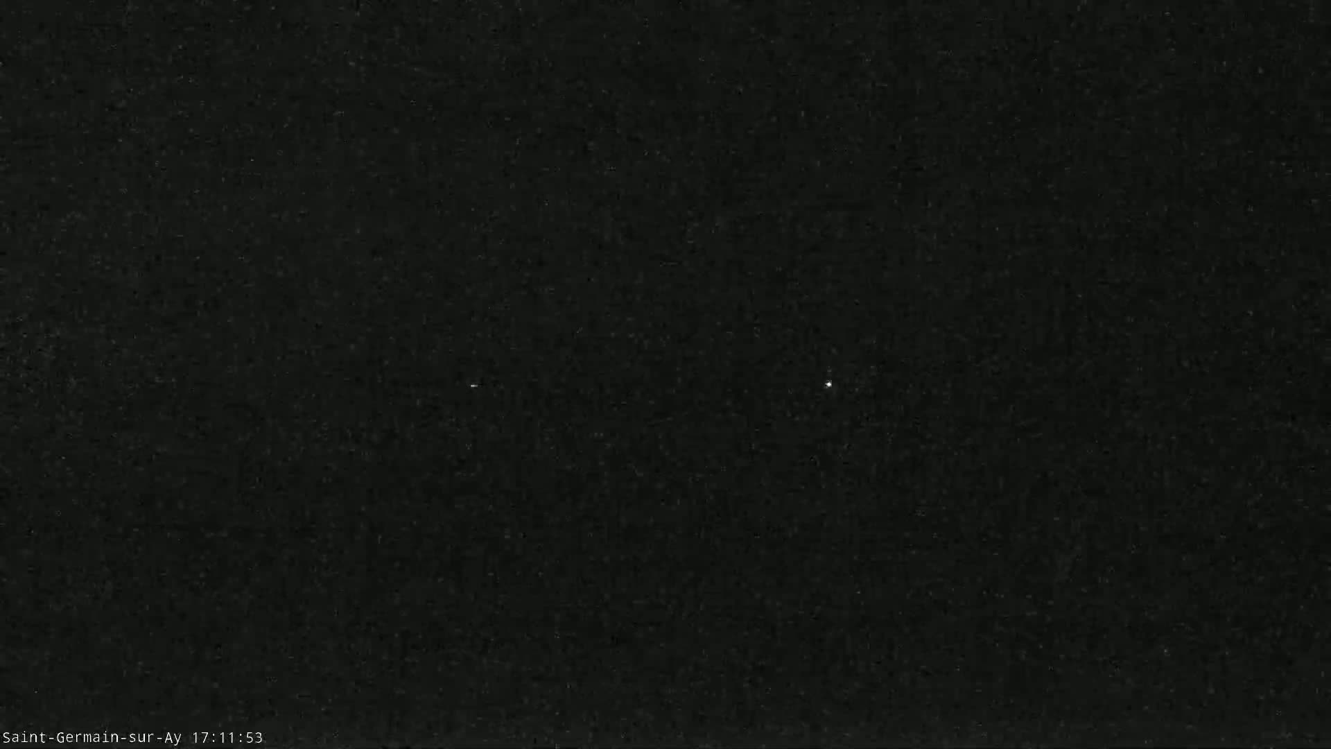 A dark, possibly nighttime, image shows a mostly black sky with two faint, distant lights.