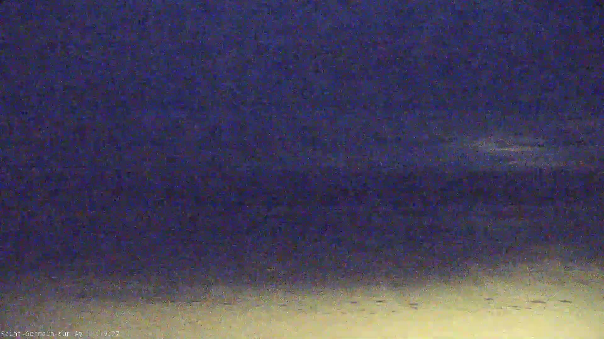 A dark blue nighttime sky transitions to a pale yellow ground, possibly sand.