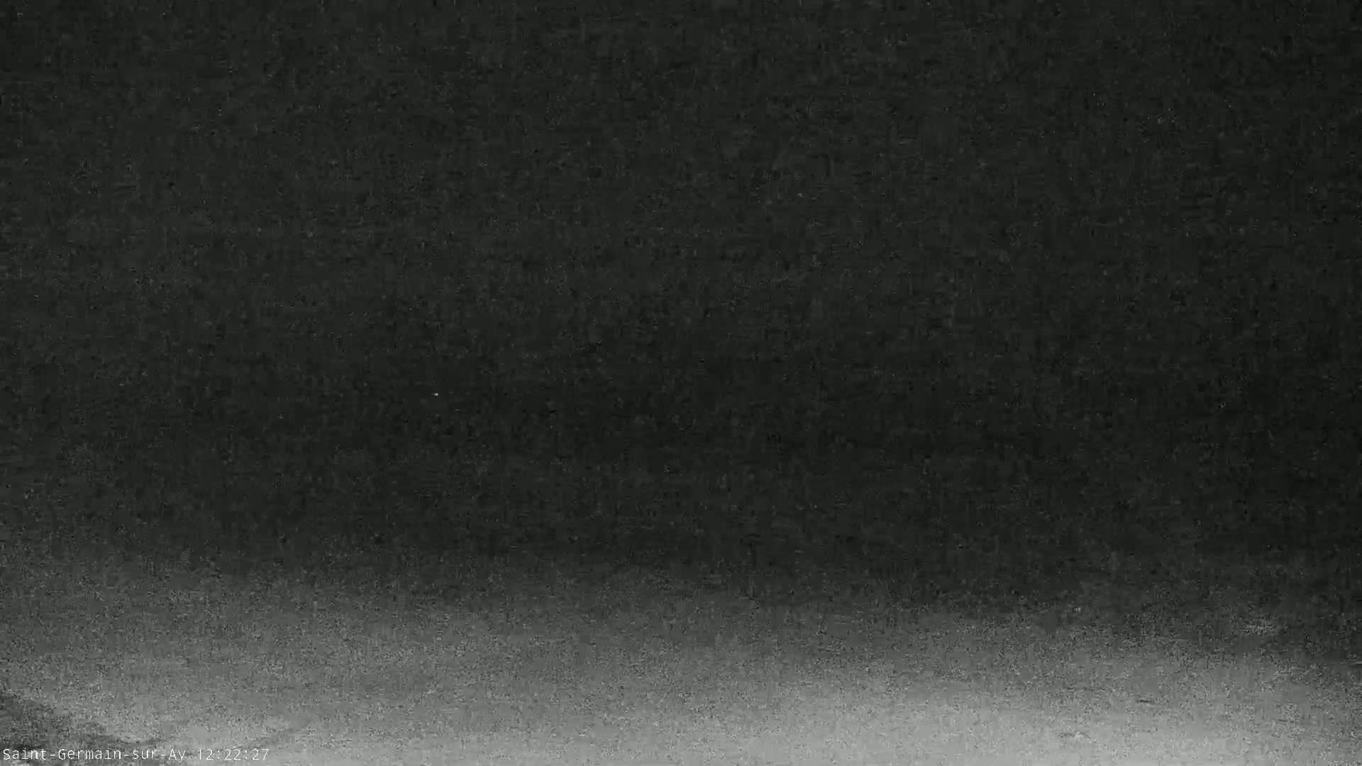 A dark, grainy image shows a gradual darkening from light gray at the bottom to black at the top.