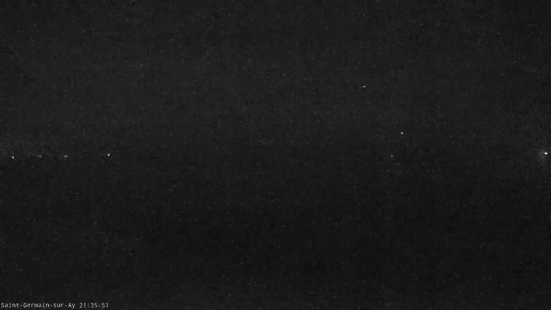 A dark, nighttime sky shows a few faint lights in the distance.