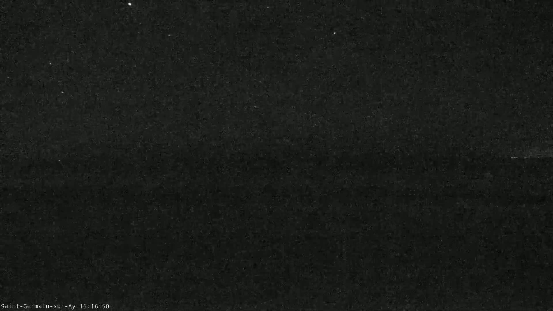 A grainy, dark image shows a mostly black sky at night.