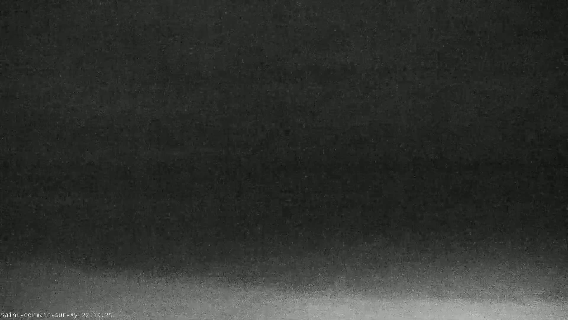 A dark, blurry image shows a mostly black sky gradually lightening to a gray horizon.