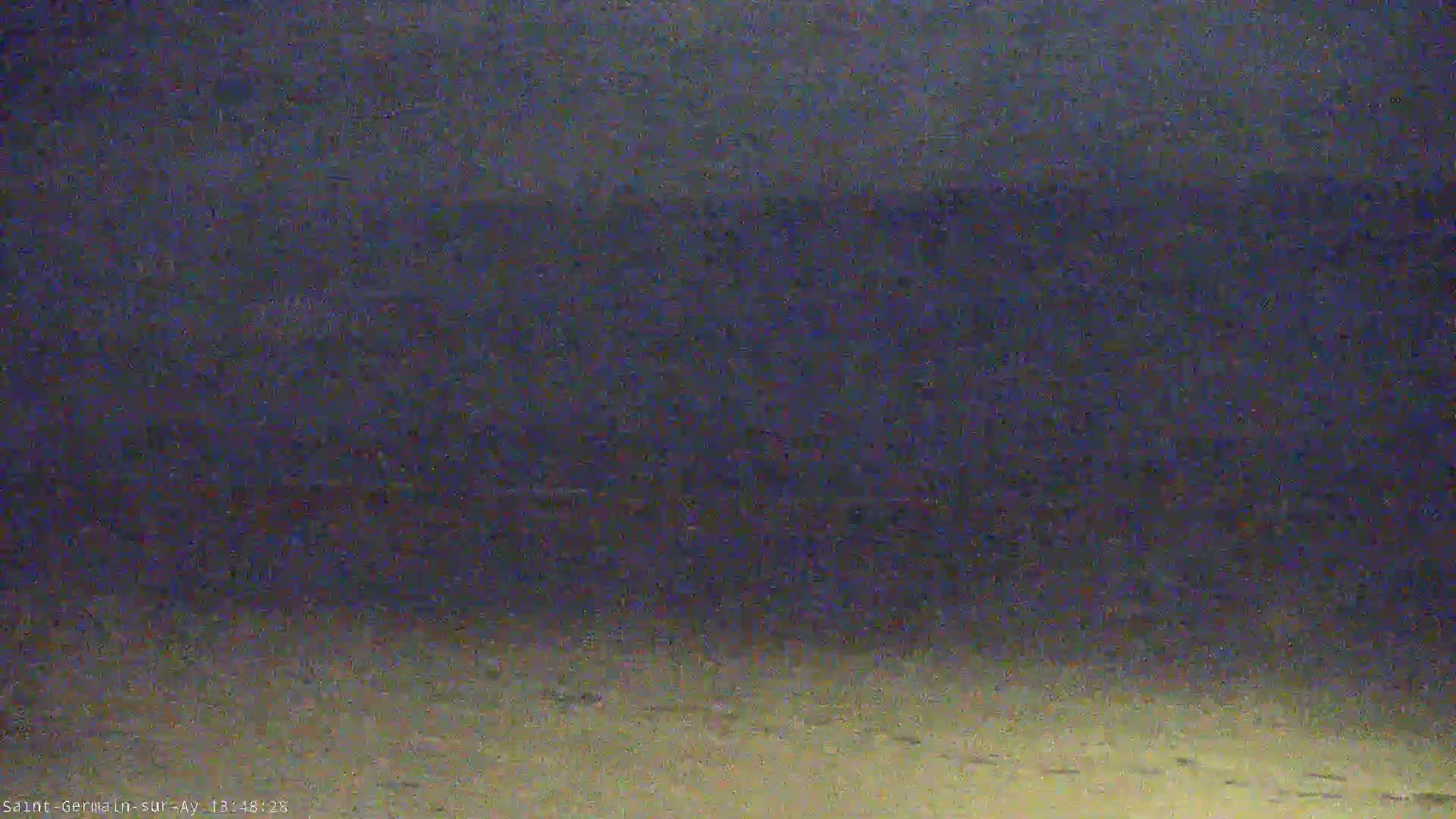 A low-light, blurry image shows a dark beach or shoreline at night.