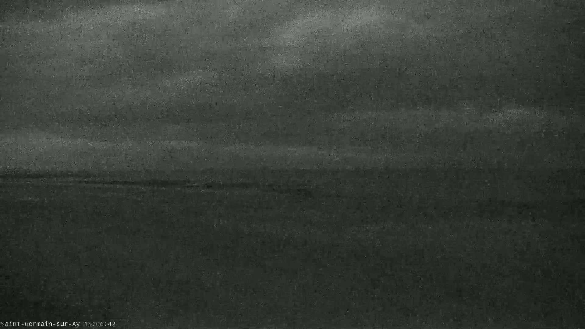 A dark, overcast sky looms over a flat, dark landscape.