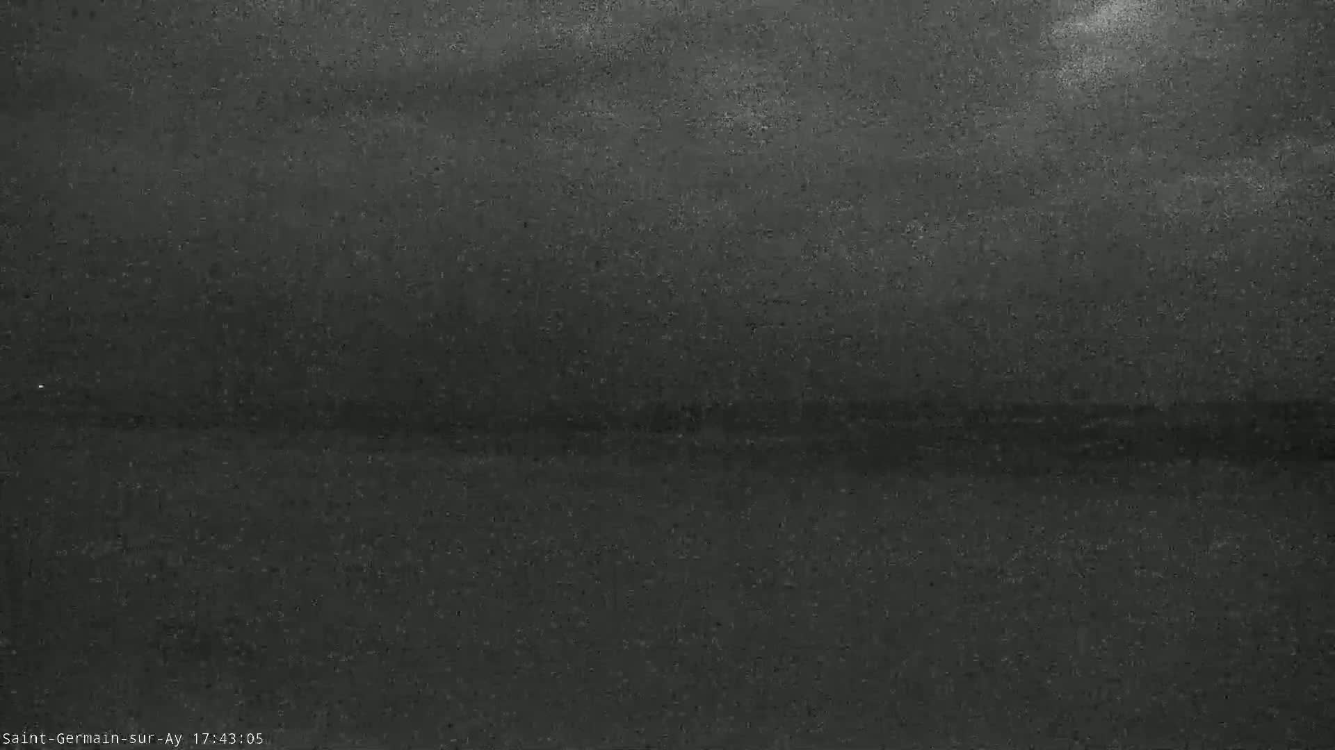 A dark, possibly overcast sky is visible above a dark, flat body of water.