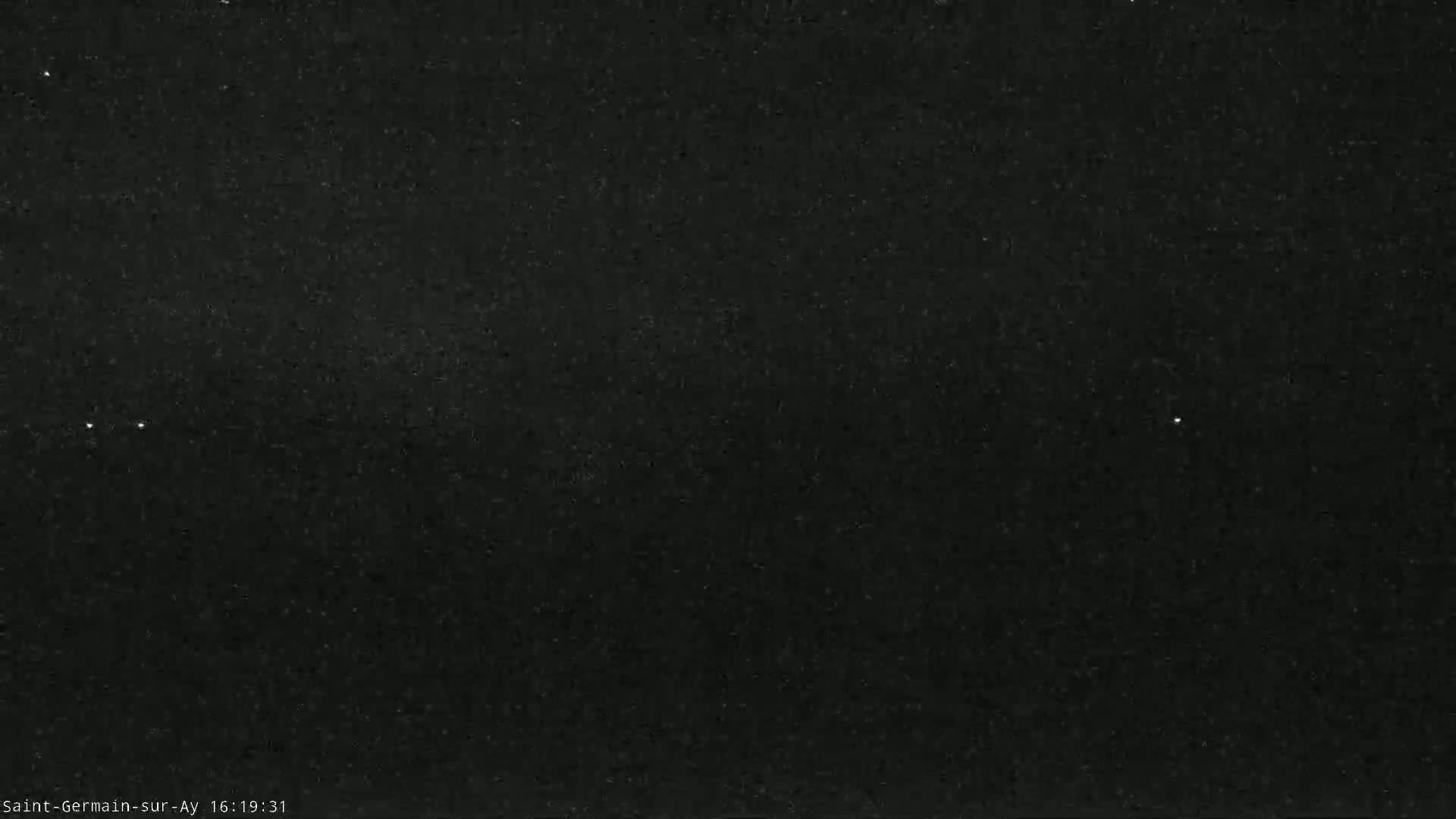 A mostly clear night sky shows a few faint stars and a blurry galaxy.