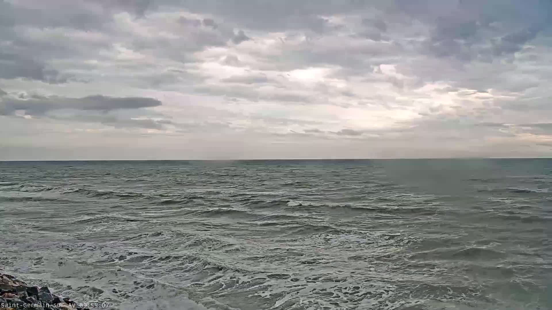 A gray, overcast sky hangs over a choppy sea with small waves.
