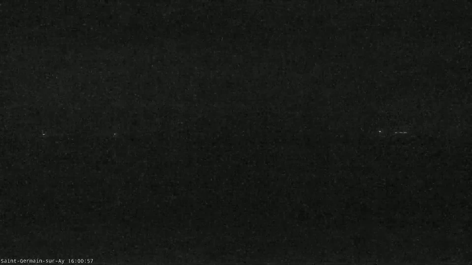 A dark, possibly nighttime image shows a few faint lights in the distance.
