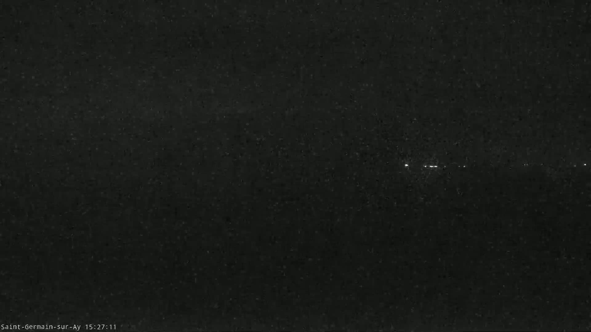 A nighttime, long-exposure shot shows a line of faint lights in the distance.