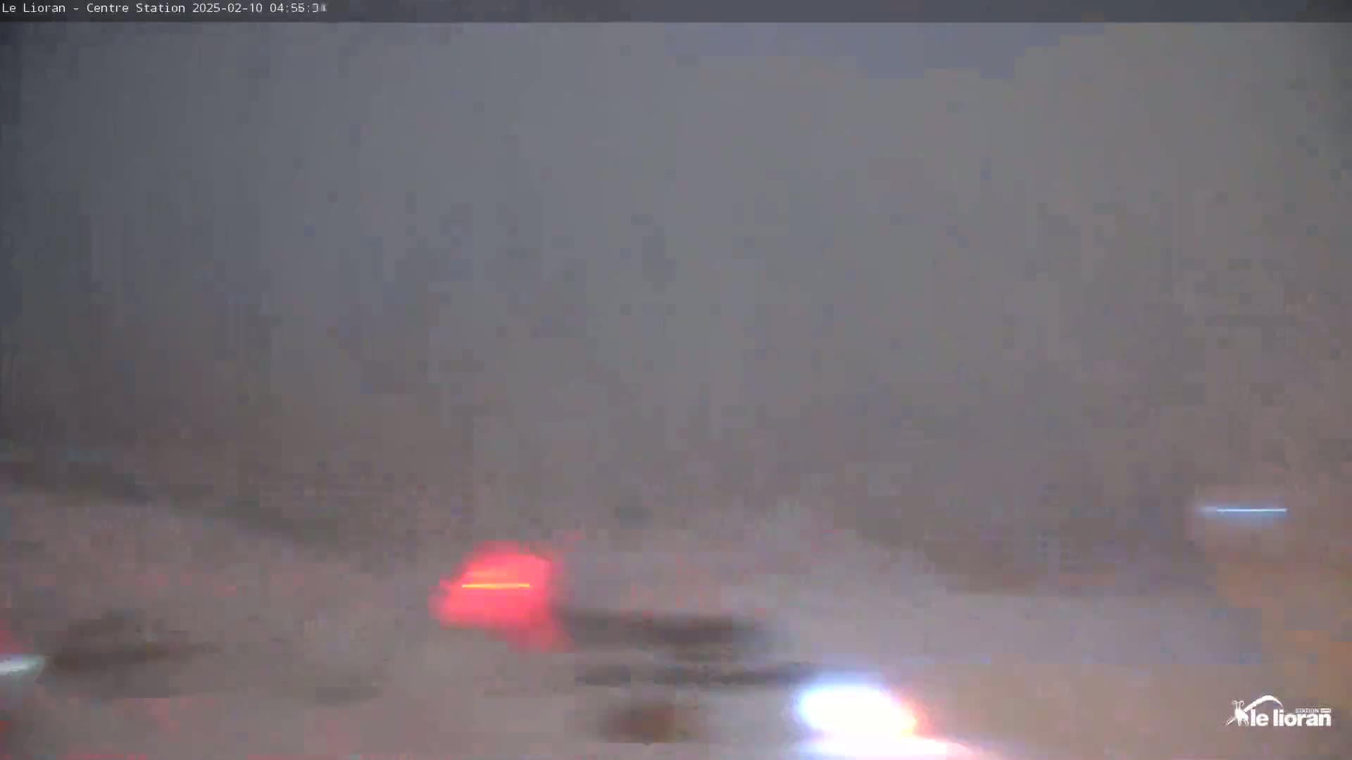 A blurry image shows vehicles' taillights and headlights in heavy fog or mist.