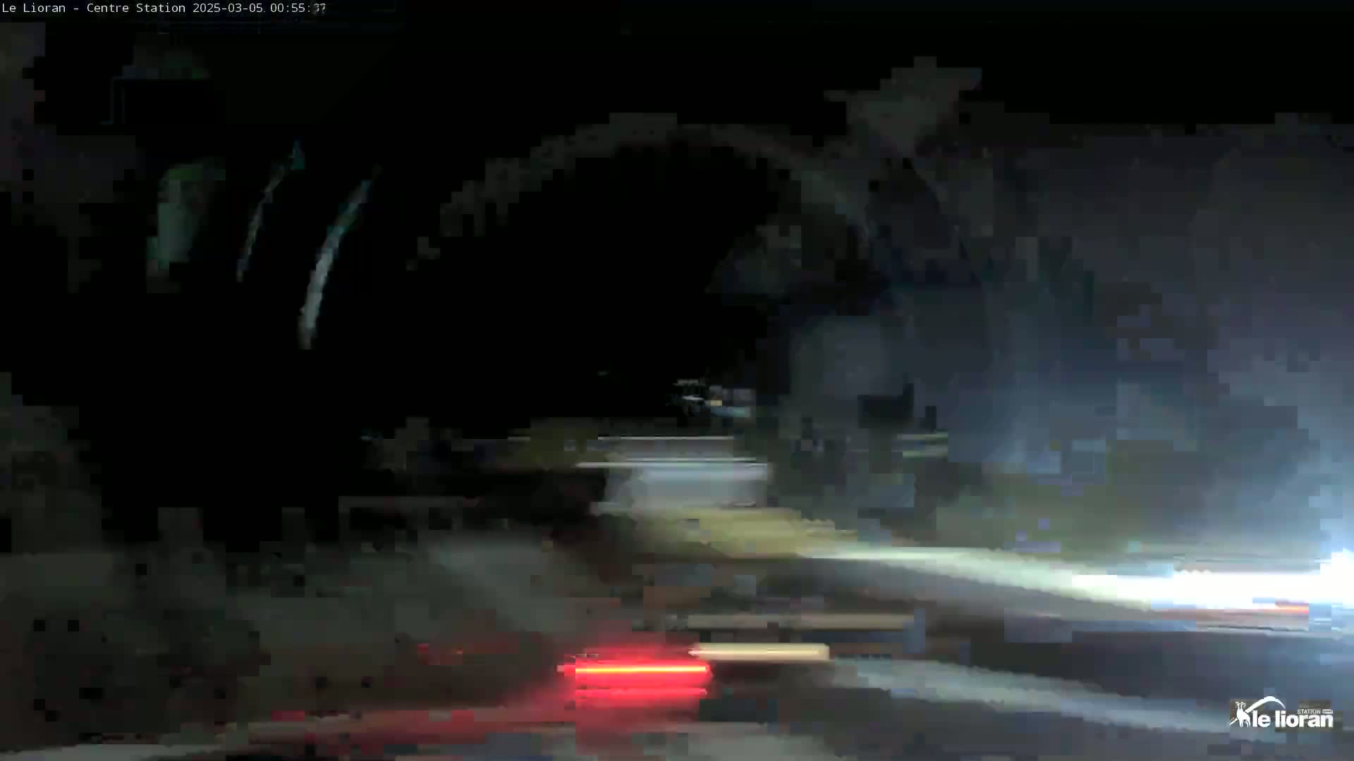 A nighttime, blurry view of a road with vehicle taillights visible, possibly in foggy or misty conditions.