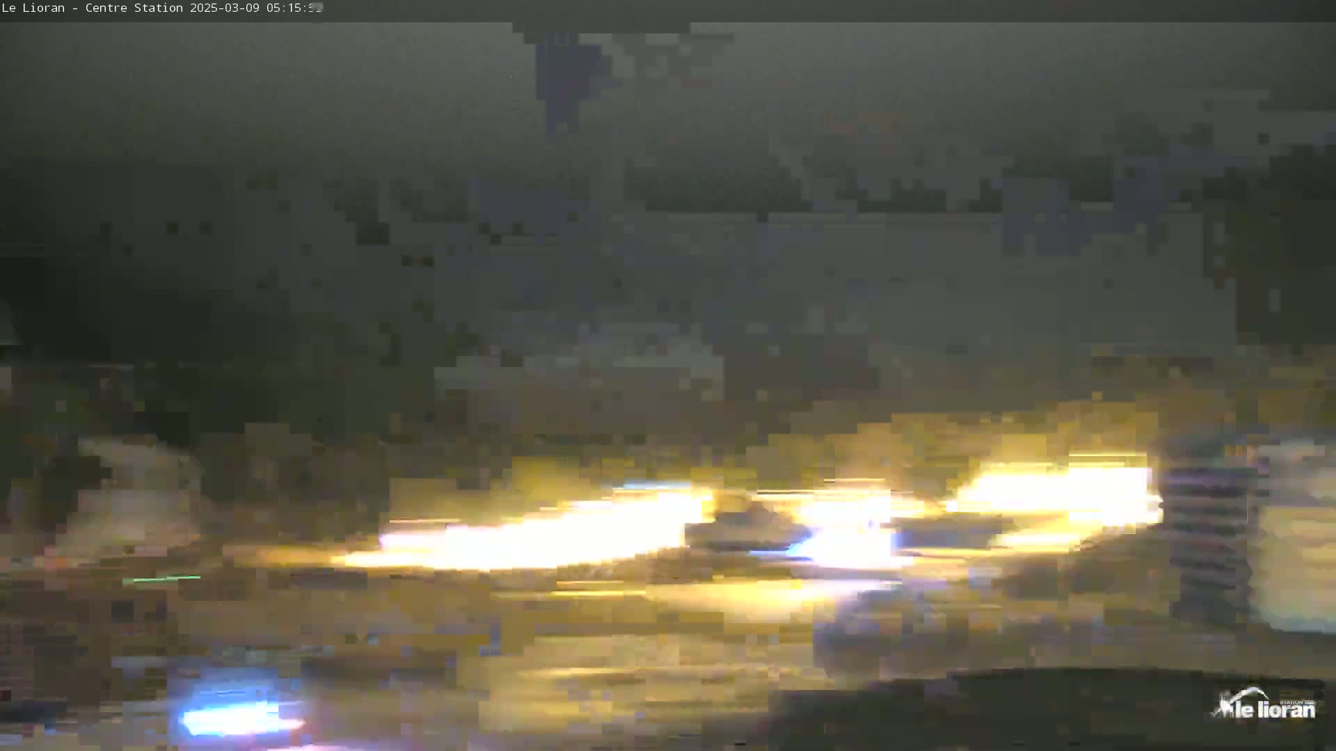 A blurry nighttime image shows streaks of light from vehicles moving on a road.