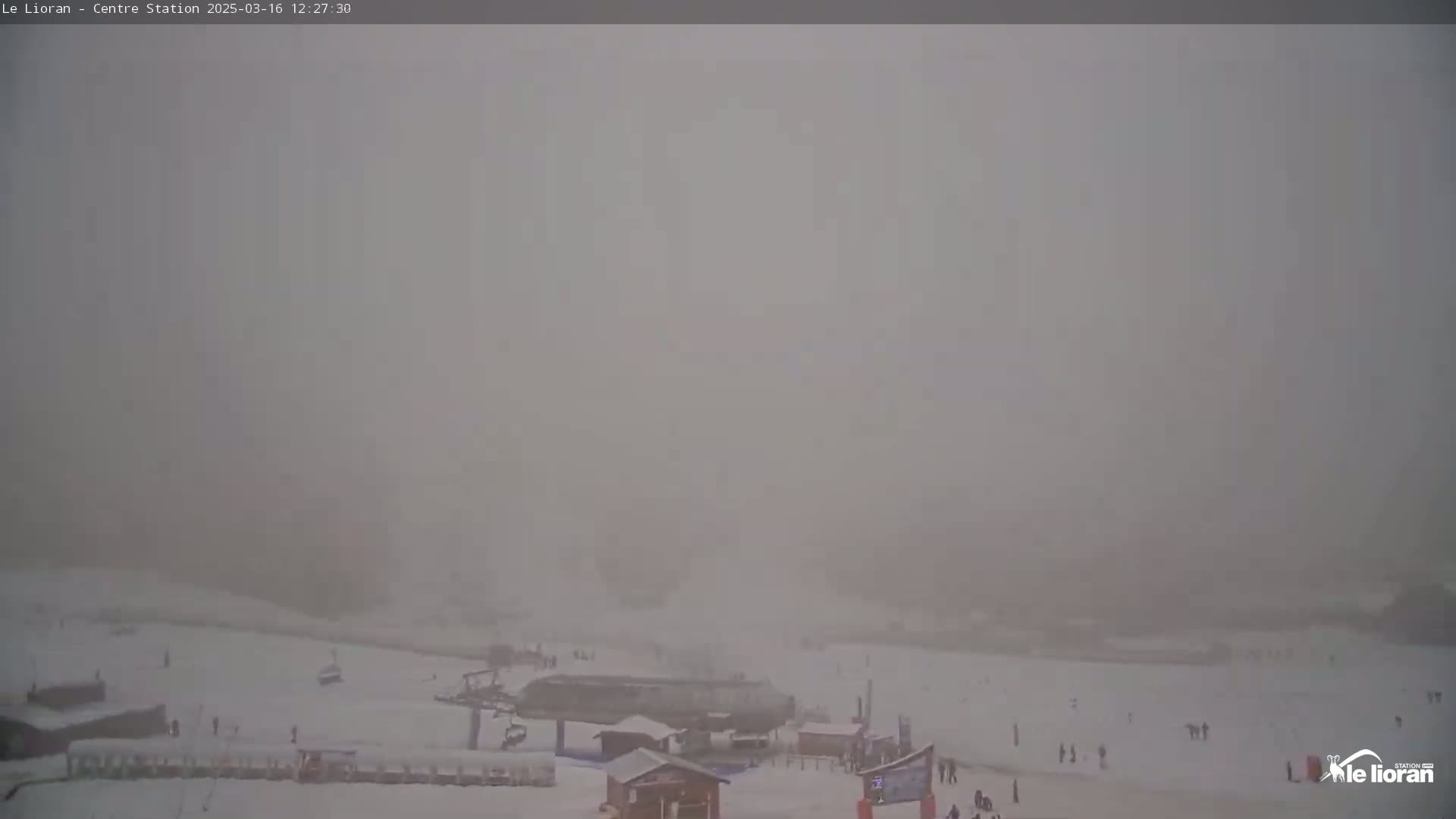 A snowy ski resort is shrouded in thick fog.