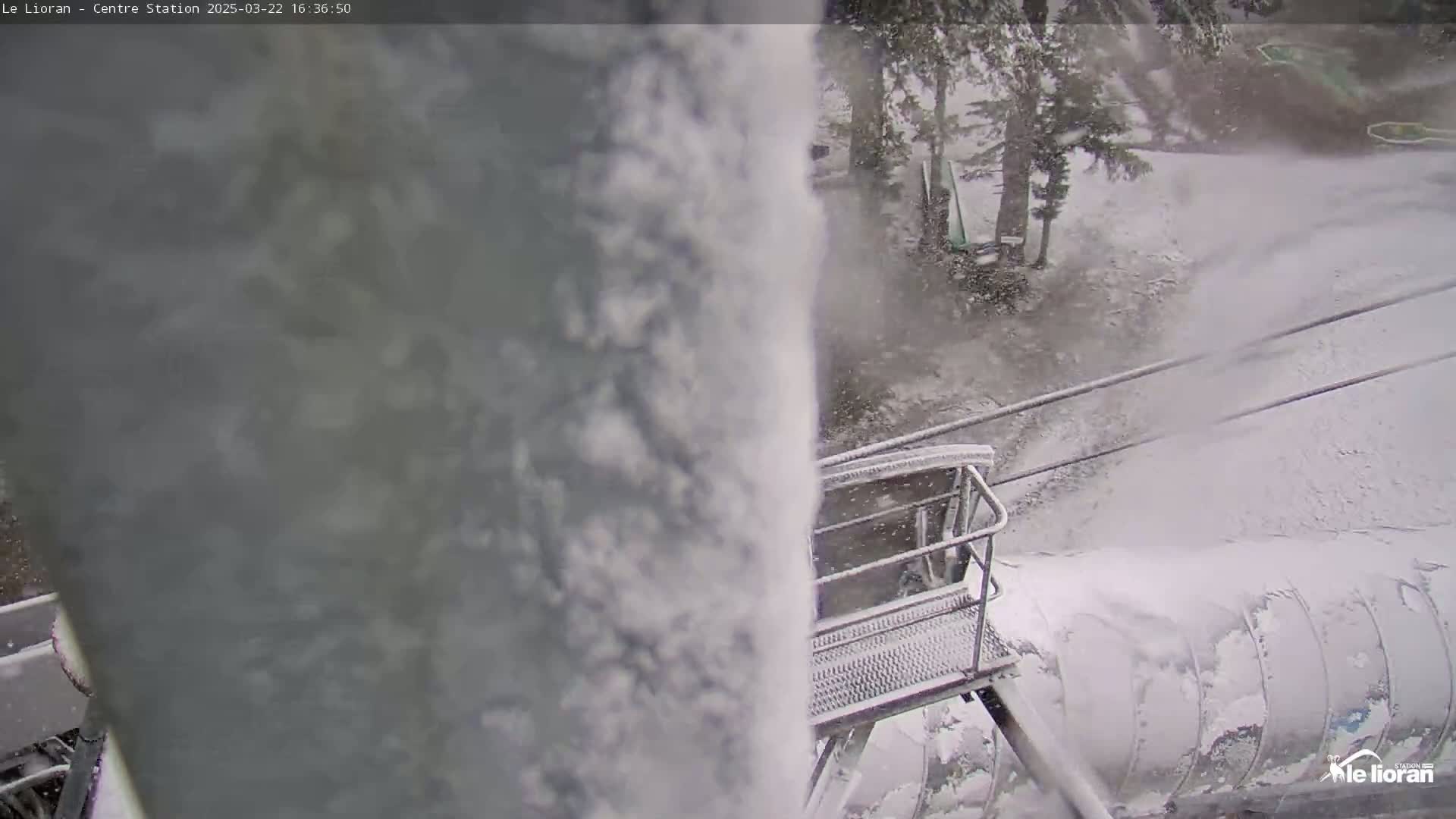 A snow-covered ski lift chair is visible through a thick snowstorm.