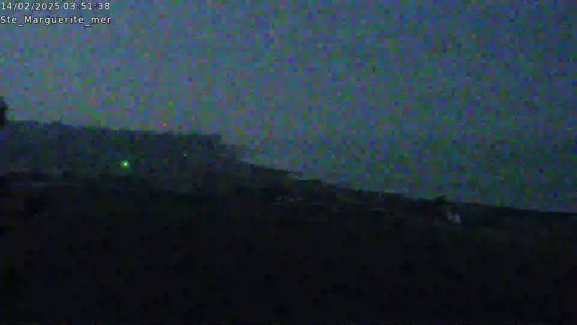 A dark, nighttime outdoor scene shows a low hill or embankment under a dusky blue-purple sky.
