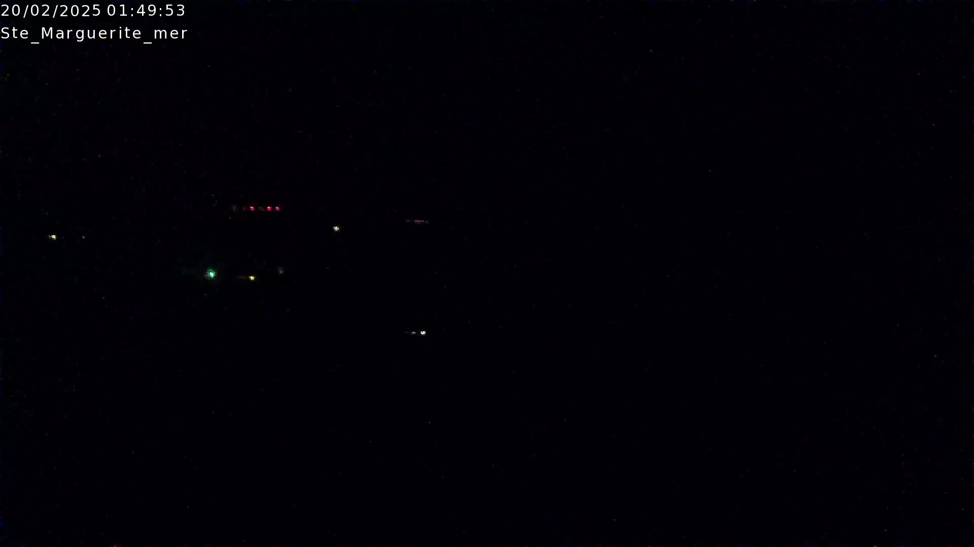 A nighttime, dark scene with a few distant lights visible.