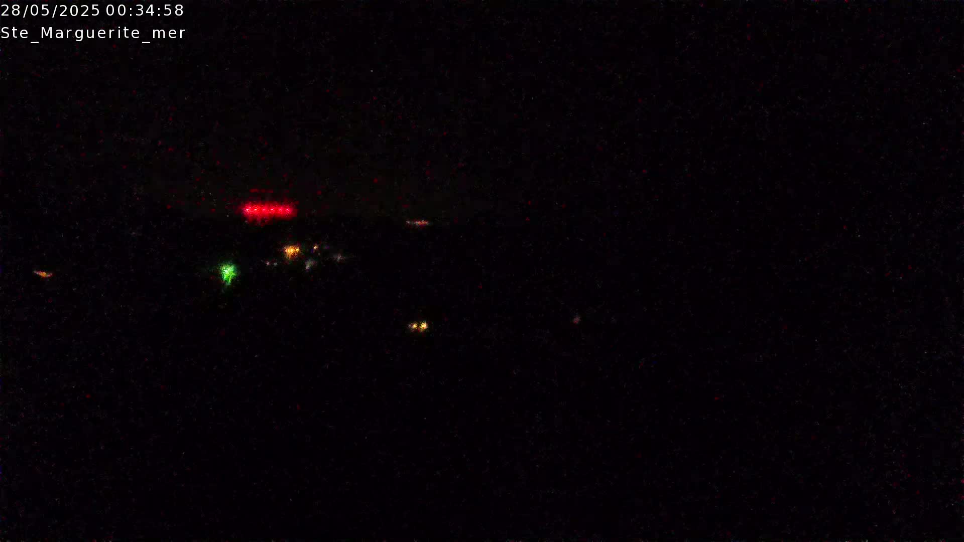 A nighttime, dark scene shows a few distant, small lights.