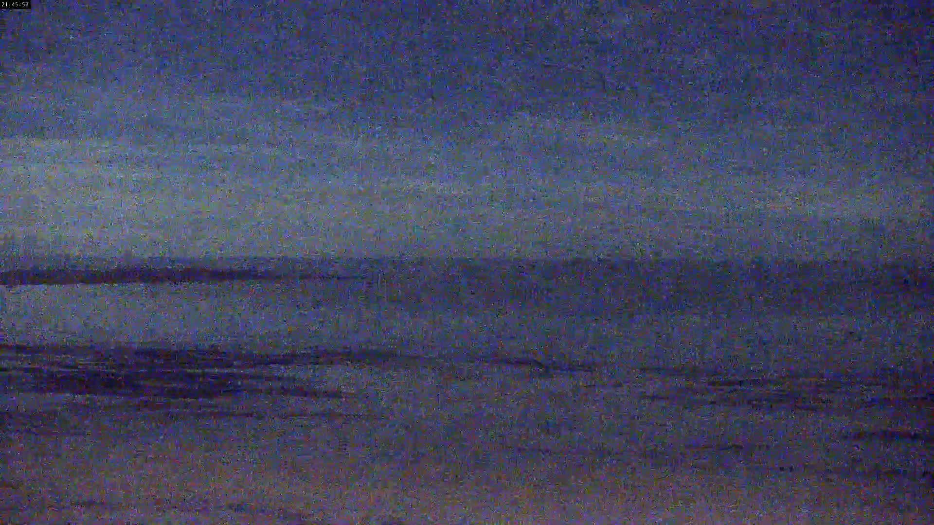 A dark, blurry image shows a body of water under a twilight sky.
