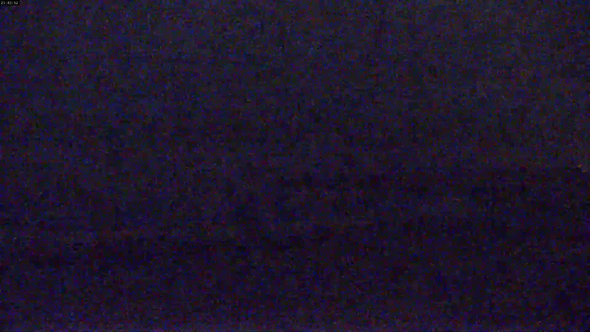 The image shows a dark, grainy, and blurry view of an indistinct scene at night.