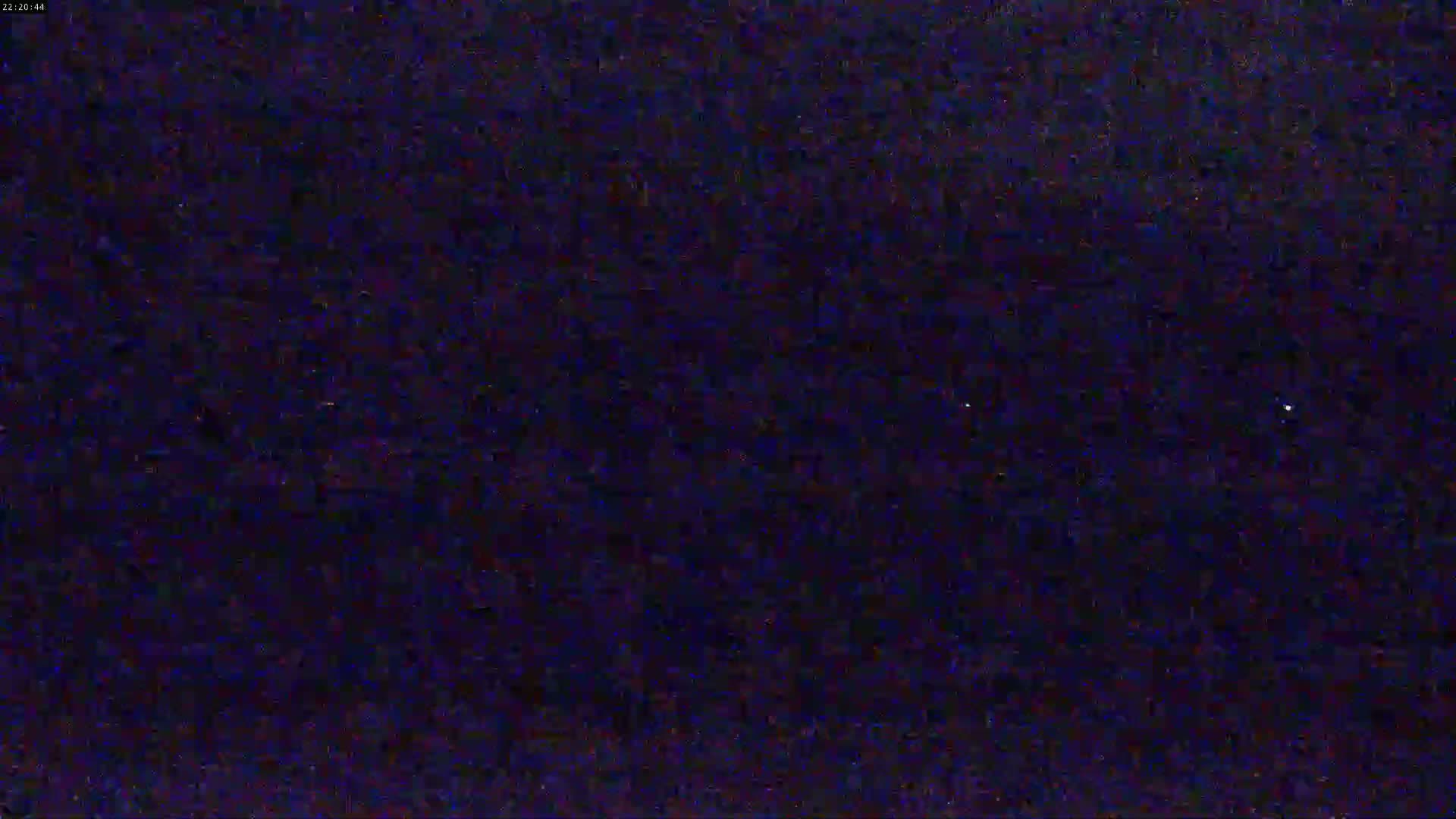 A nighttime image shows a dark, mostly uniform texture with a few brighter specks.