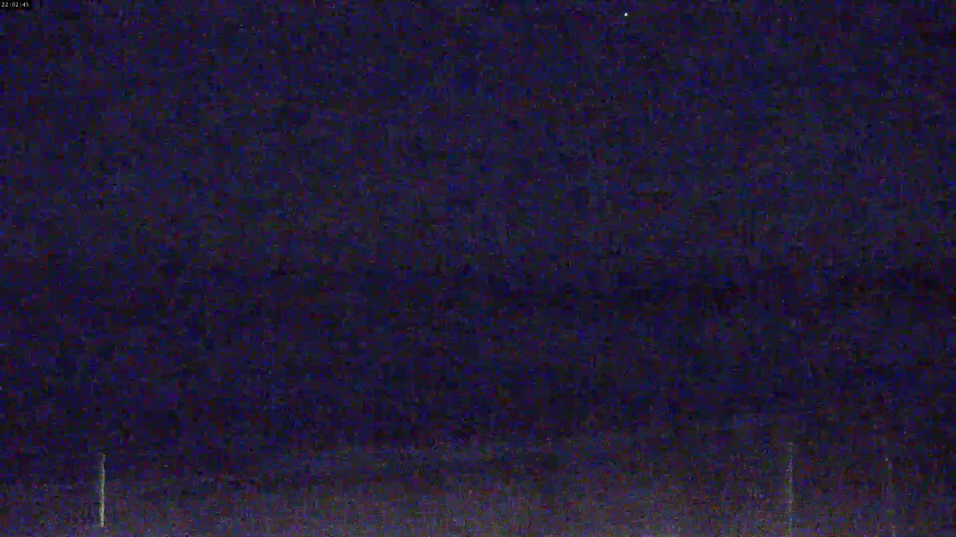 A dark, nighttime scene shows a mostly featureless expanse under a clear, dark sky.
