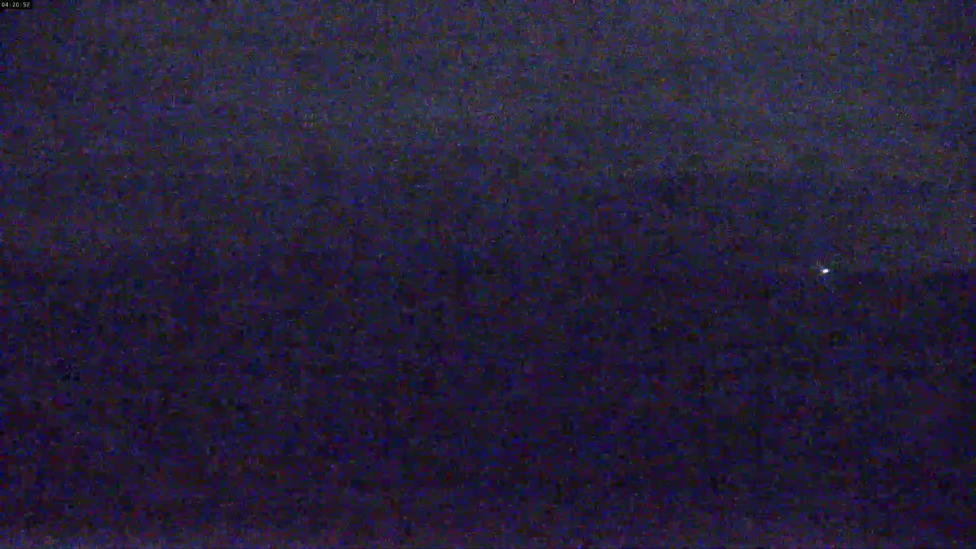 A nighttime, dark blue sky is visible with a single, faint light source in the distance.