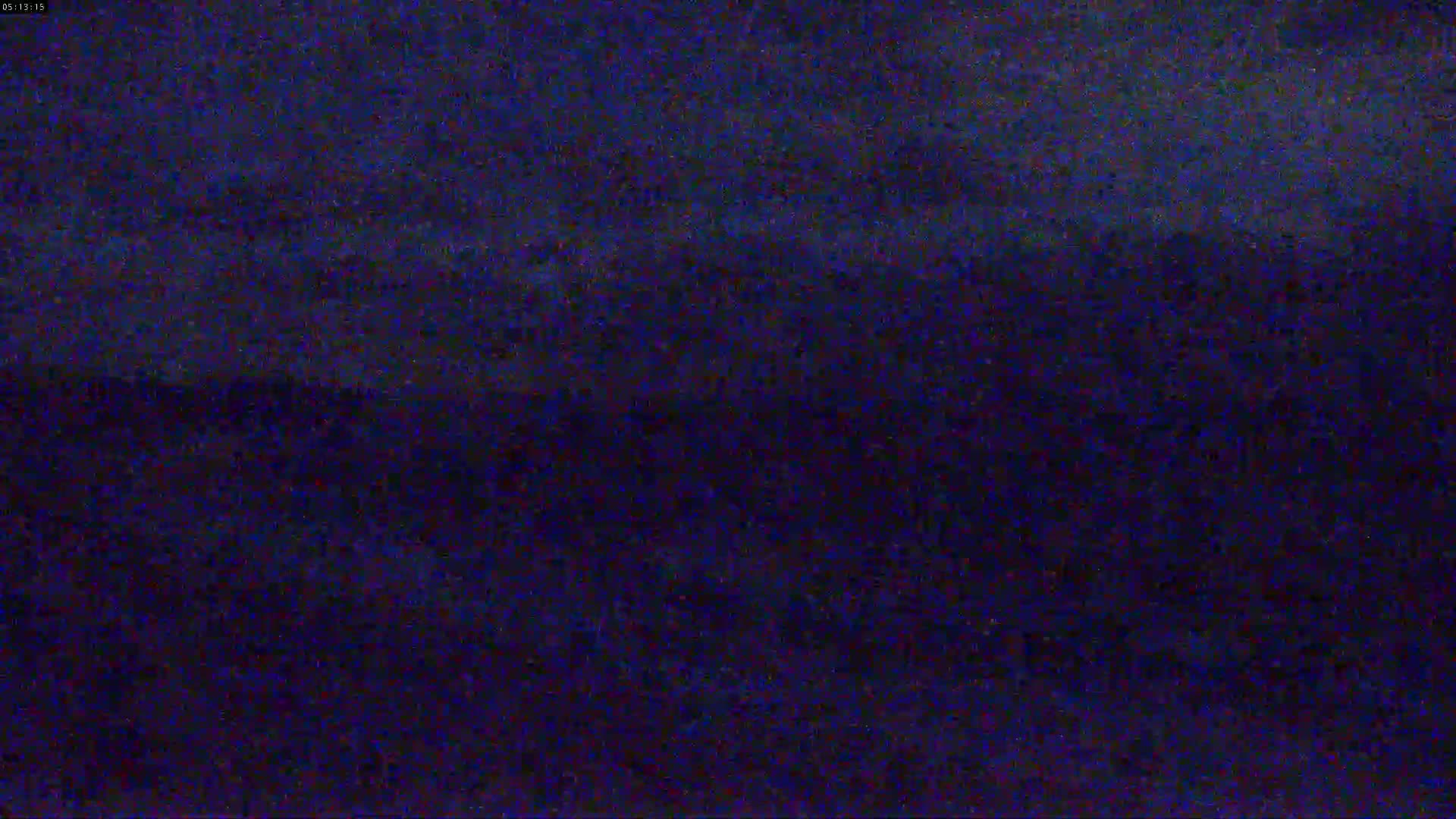 A dark, blurry image shows a night scene with a dark blue sky.