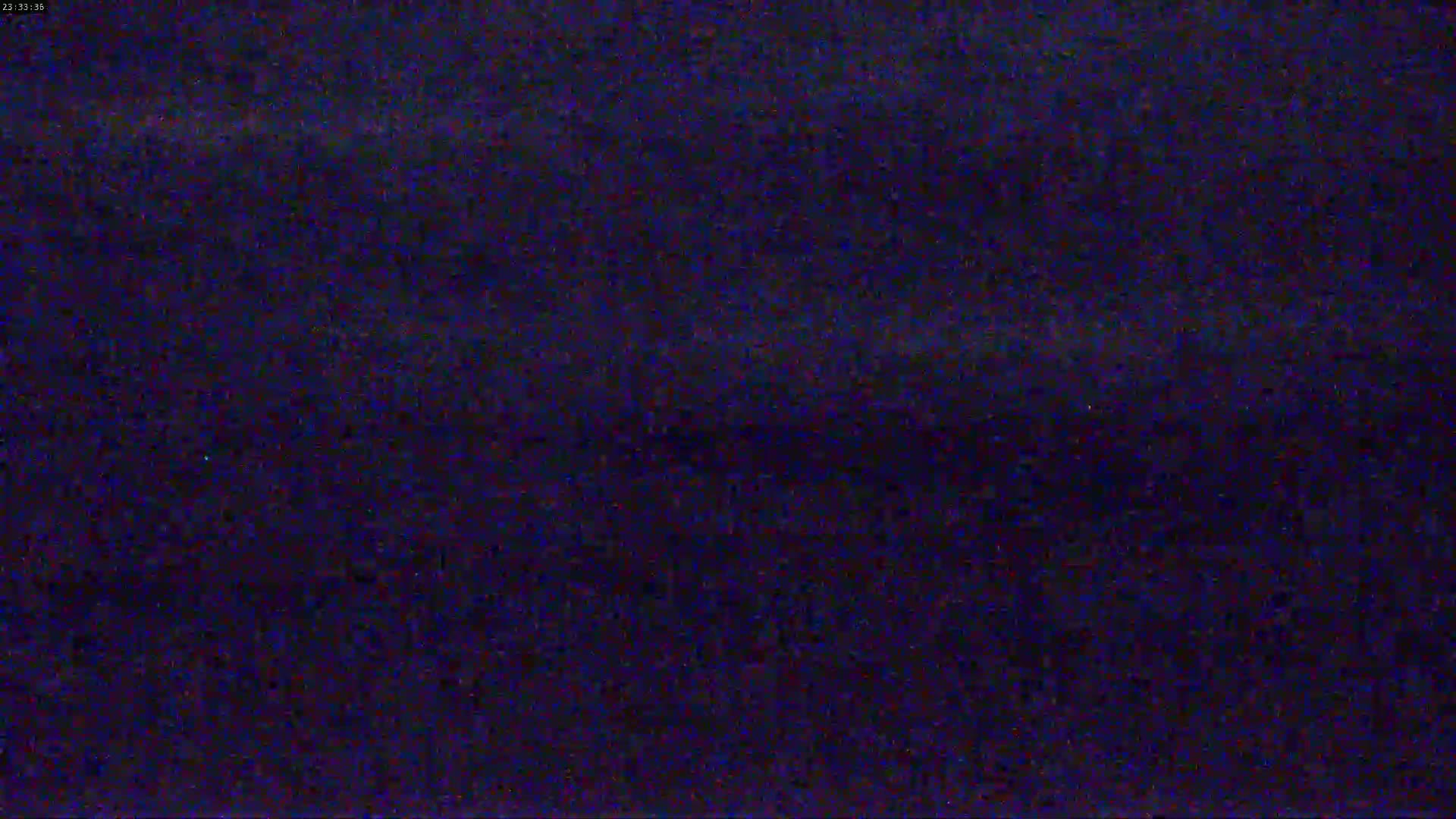 The image shows a dark, grainy, and blurry view of what appears to be nighttime.