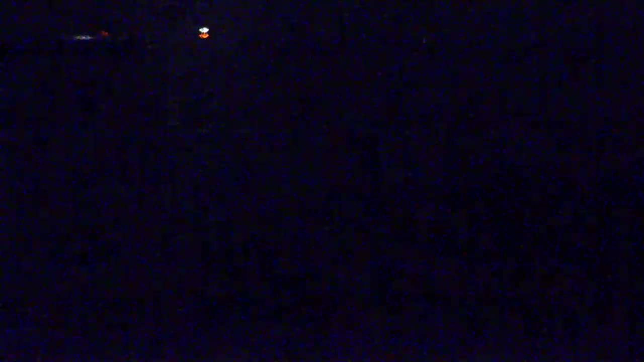 A dark, nighttime scene shows two small, distant lights.