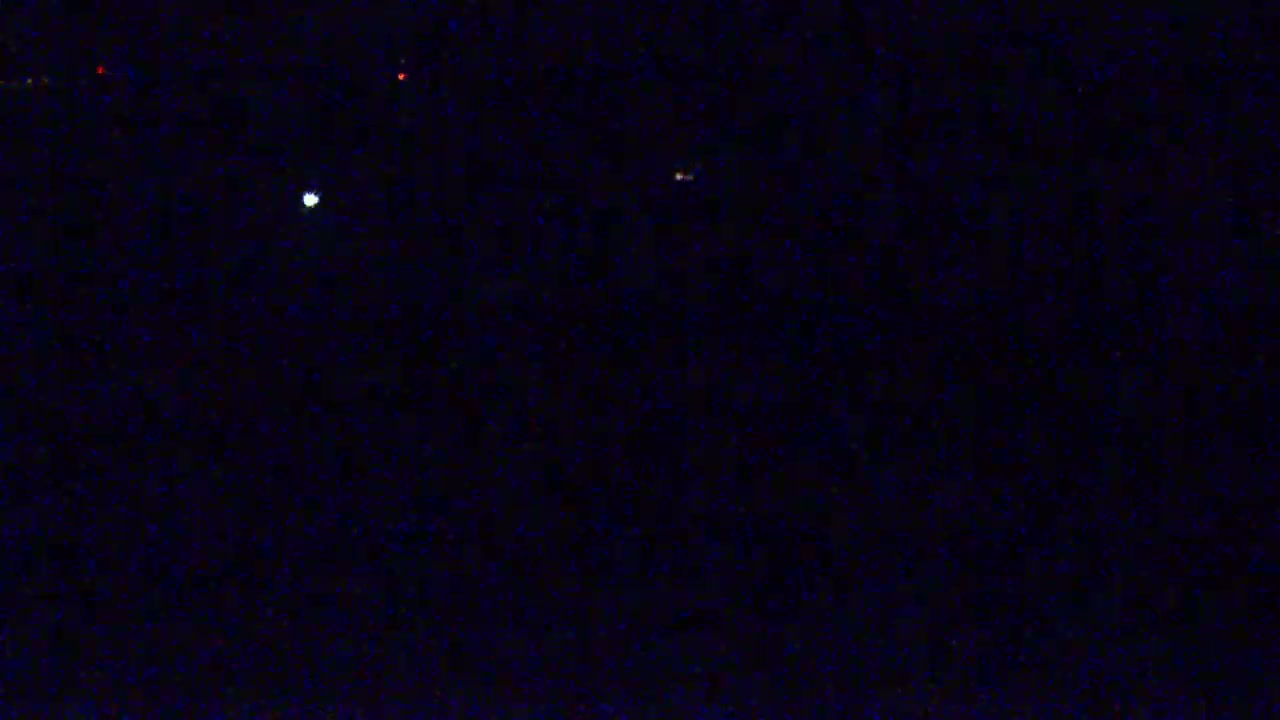A dark, night sky shows a few faint lights, possibly stars or distant lights.