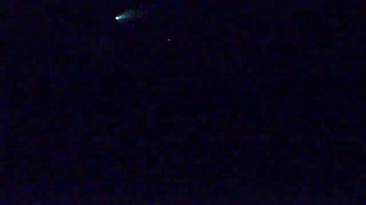 A dark night sky shows two faint, luminous objects.