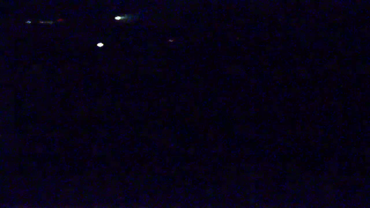 A dark, nighttime scene shows several faint, distant lights.