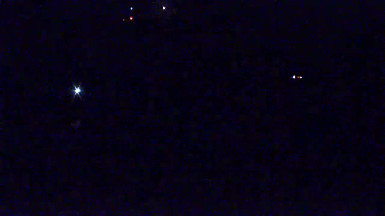 A dark night sky shows several bright stars and faint points of light.