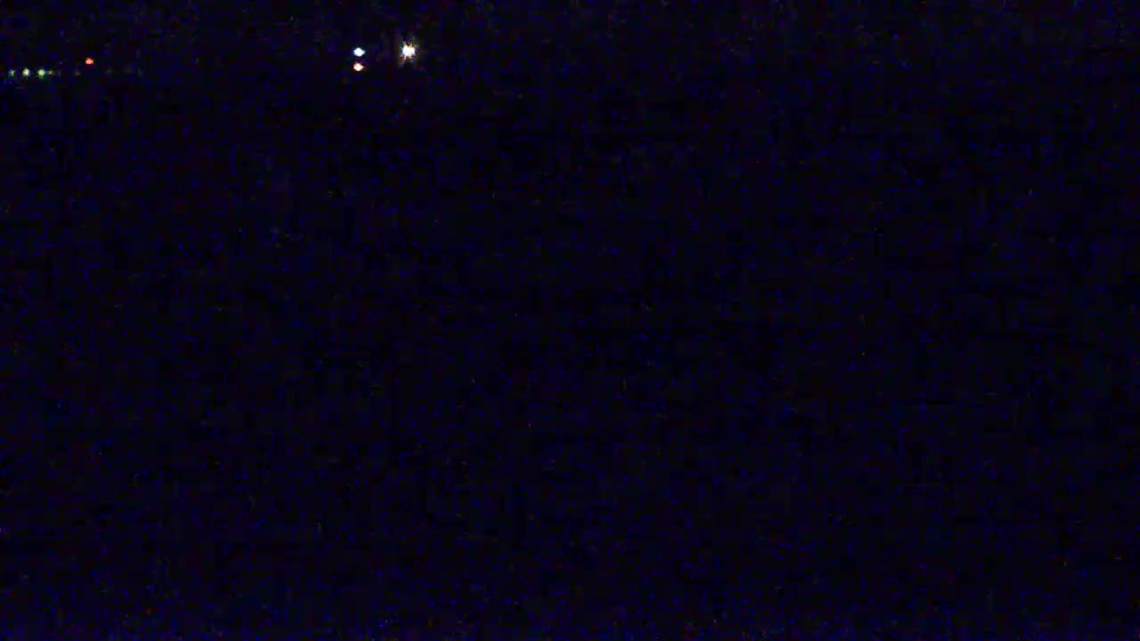 A dark, nighttime scene shows a few distant lights.