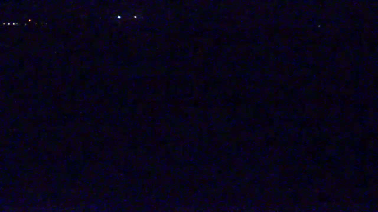 A dark, nighttime scene with a few distant lights visible.