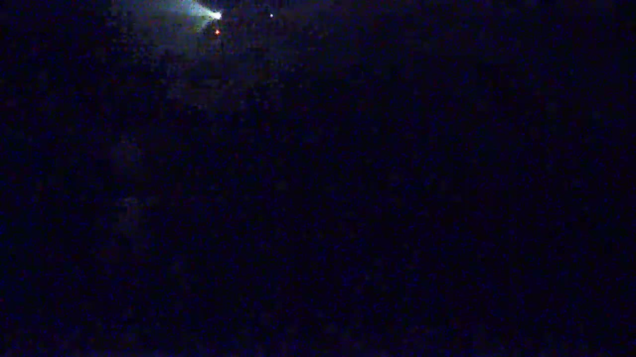 A dark, nighttime scene is illuminated by a bright light source in the upper left corner.